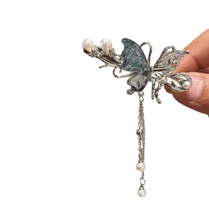 Elegante fermaglio per capelli a farfalla con nappa d'argento e perle su sfondo bianco