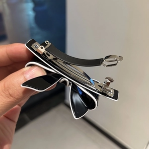 Elegant acetate bow hair clip with black and white contrast design and metal spring clip