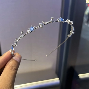 Vue détaillée du serre-tête argenté avec étoiles à paillettes bleues et strass incrustés