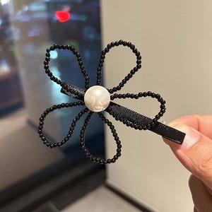 Pince à cheveux fleur avec perles noires et centre en perle blanche pour un style chic français