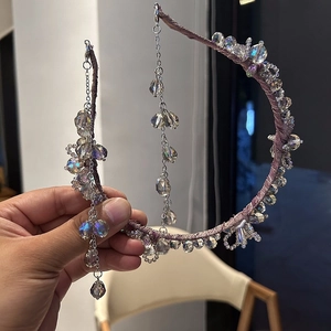 Détail du serre-tête mauve de luxe avec perles en cristal et pompons en argent