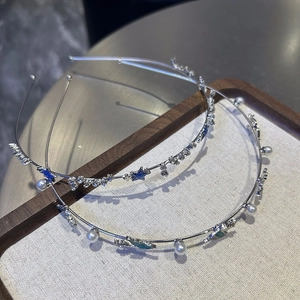 Détail du serre-tête argenté avec étoiles bleues pailletées, perles et strass brillants