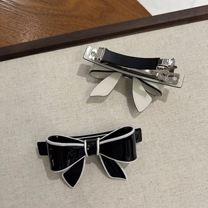 Detail of elegant black and white bow hair clips with silver anti-slip metal spring clips