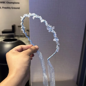 Detailansicht eines blauen Schmetterling-Haarreifs mit Perlen und langen Organza-Bändern
