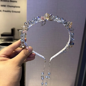 Détail d'un serre-tête artisanal avec franges en cristal et perles de nacre
