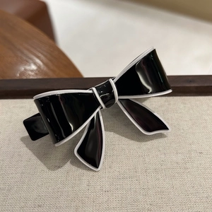 Detailed view of the elegant black and white bow hair clip with high-gloss finish