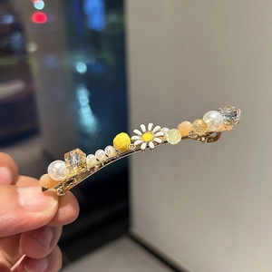 Detail of handmade daisy hair clip with pearls and sparkling champagne crystals