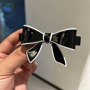 Elegant medium acetate bow hair clip with classic black and white contrast design
