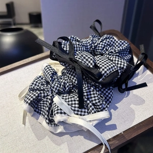 Classic black and white checkered scrunchies with satin bows for elegant ponytail styling