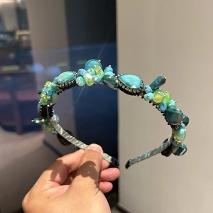 Detail of luxury emerald green and blue crystal headband with faceted gemstone inlay