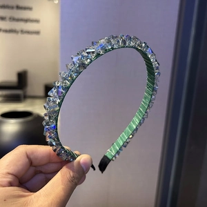 Close-up of handmade green headband with multi-faceted crystals and soft fabric ends