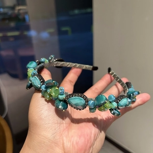 Detailed view of handmade crystal headband featuring green gemstones and vintage beads