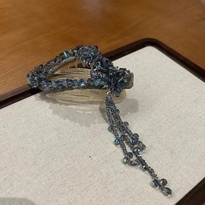 Detail view of crystal flower hair claw clip with blue tassels and sparkling beads
