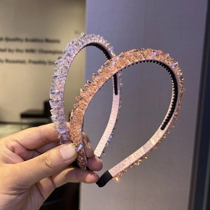 Detailed macro view of two handmade crystal beaded headbands in pink and clear colors