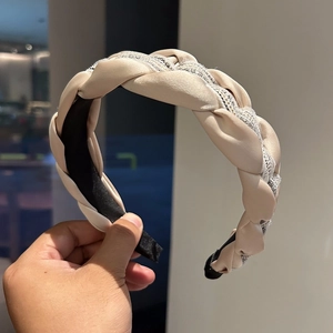 Détail d'un serre-tête tissé en satin champagne et maille scintillante avec doublure noire