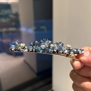 Elegant gold metal hair clip with dark blue floral fabric and faceted crystal inlay
