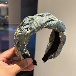 Detail of blue denim braided headband with gold stars and silver metal rivets