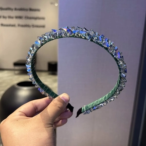 Close-up of green headband featuring faceted crystal beads with ice-like texture