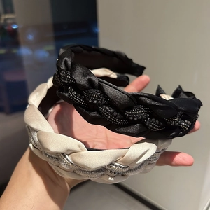 Gros plan de serre-têtes en satin tressés à la main avec strass scintillants et perles