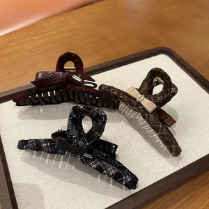 Detailed view of three tweed checkered hair claws with elegant handmade bows