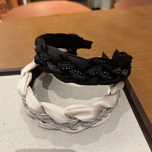 Détail de serre-tête tressé en noir et champagne avec des accents de perles brillantes