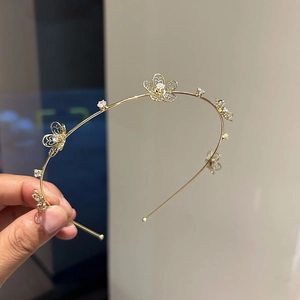 Close-up of golden metal headband with hollow flowers and sparkling zircon stones