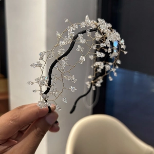 Close-up of handmade bridal headband with clear crystal beads and gold wire mesh weaving