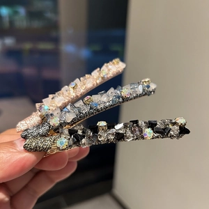Détails macro d'un lot de 3 barrettes à cristaux avec strass roses, bleus et noirs brillants