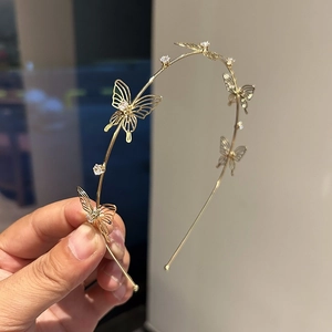 Detailed view of golden butterfly headband with hollow silk texture and zircon inlay