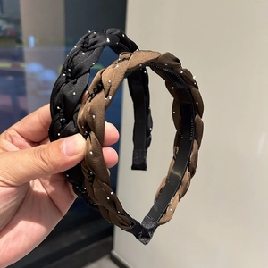 Dettaglio cerchietto intrecciato con strass, denti antiscivolo e finitura satinata marrone
