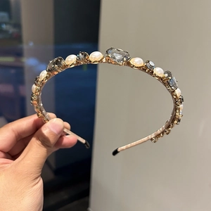 Close-up of elegant gold headband featuring alternating pearls and faceted rhinestones