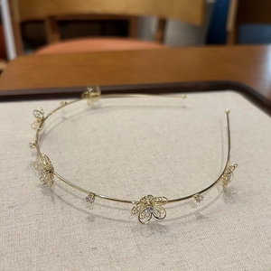 Close-up of golden hollow flower headband with rhinestones and zircon details