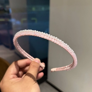 Dettaglio macro del cerchietto rosa con perle eleganti e perline di cristallo lucide