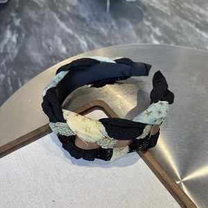 Detail view of woven denim headband featuring gold star embroidery and a braided wide design