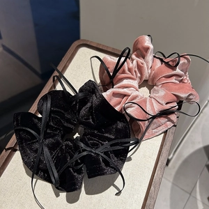 Detail von Samt-Haargummis in Schwarz und Rosa mit eleganten Schleifendetails