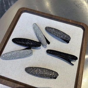 Detail of 6pcs crystal rhinestone snap hair clips on gray velvet display tray
