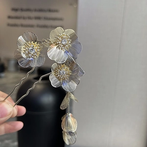 Detail of floral hair stick with delicate textured petals and crystal tassels
