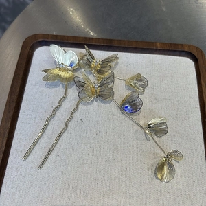 Detail of golden butterfly hairpins with mesh wings and elegant long tassels