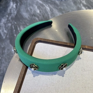 Detail of green sponge headband with vintage camellia flowers and pearl accents