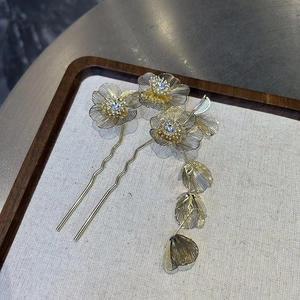 Detailed macro view of golden Chinese style flower hairpins with delicate metal mesh petals
