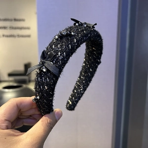 Close-up of black tweed headband with silver beads and elegant silk side bow detail