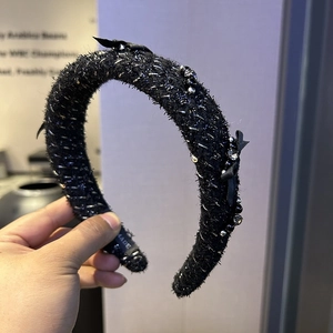 Detailed shot of black tweed headband with shiny beads and mini satin bows