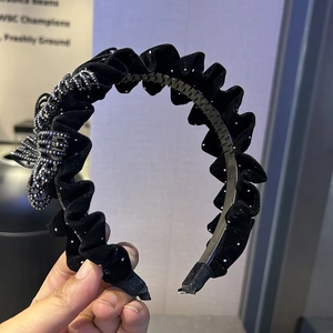 Détail du serre-tête en velours noir orné de strass brillants et de dents antidérapantes
