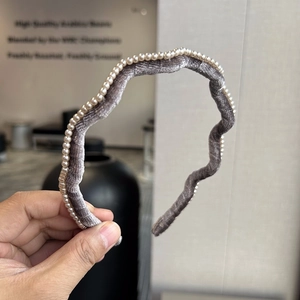 Détail du serre-tête en velours gris avec des ornements de mini perles élégantes et ondulées