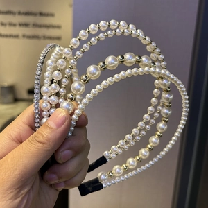 Detailed close-up of double-layer headbands with faux pearls and sparkling rhinestones