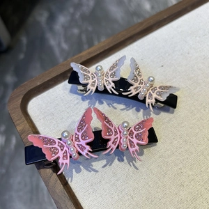 Close-up of butterfly hair clips with rhinestones and pearls on a display stand