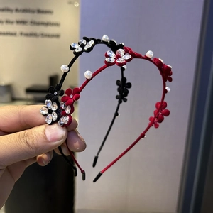 Détail de serre-têtes en velours avec fleurs en strass et perles en rouge et noir