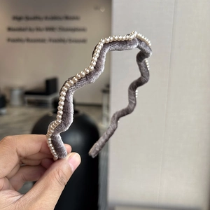 Détail d'un serre-tête en velours ondulé orné de perles élégantes pour femme