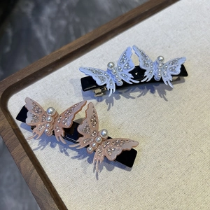 Detail of elegant butterfly hair clips with sparkling rhinestones and pearl body design