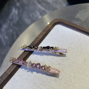 Detail of beaded crystal hair clips with purple satin wrap and multi-color gemstones